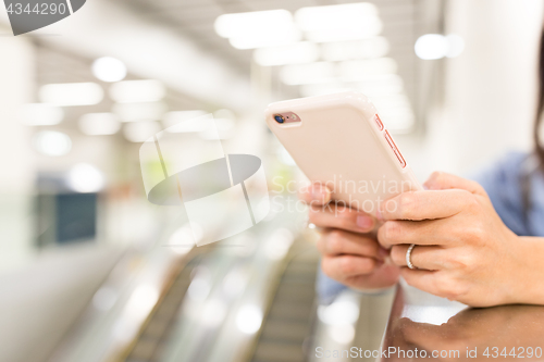 Image of Woman working on cellphone in a station