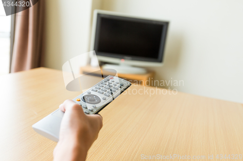 Image of Watching TV and using remote controller