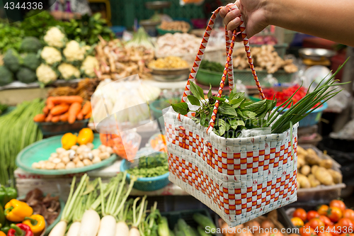 Image of Hand holding basket bag to wet market