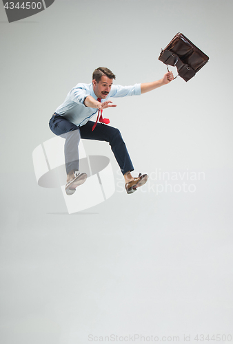 Image of Businessman running with a briefcase, isolated on gray background