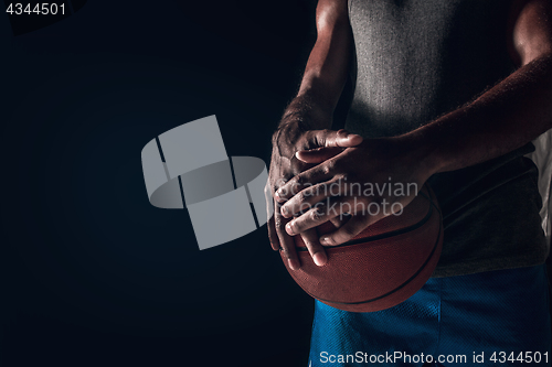 Image of The hands of a basketball player with ball