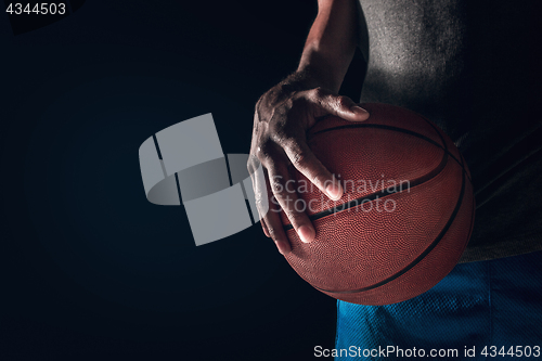 Image of The hands of a basketball player with ball