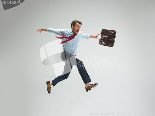 Image of Businessman running with a briefcase, isolated on gray background