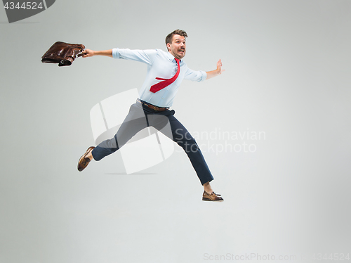 Image of Businessman running with a briefcase, isolated on gray background