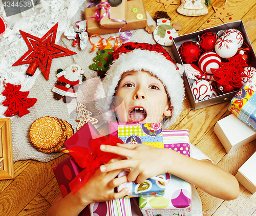 Image of little cute boy with Christmas gifts at home. close up emotional