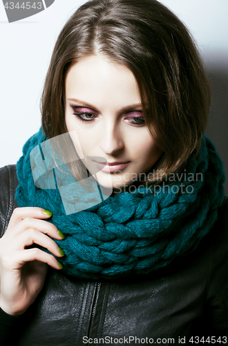 Image of young pretty real woman in sweater and scarf all over her face s