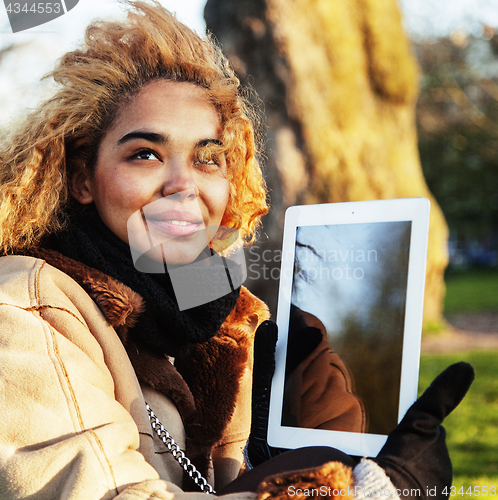 Image of young cute blond african american girl student holding tablet an