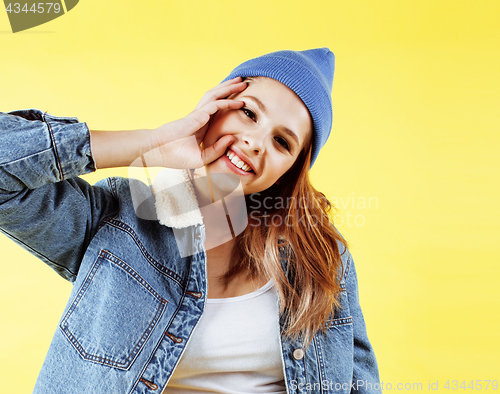 Image of young pretty teenage woman happy smiling posing on yellow background, fashion lifestyle people concept 