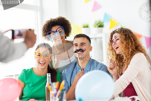 Image of friends or team photographing at office party