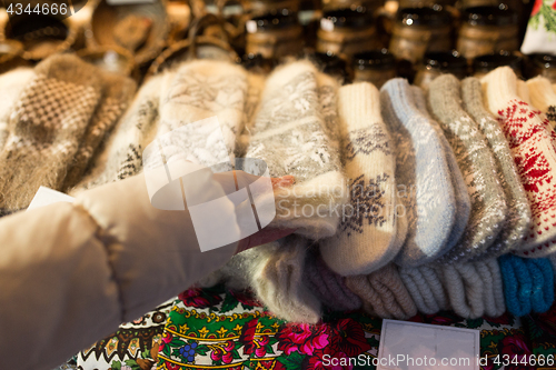 Image of woman buying woolen mittens at christmas market