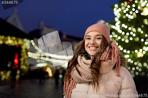Image of happy young woman at christmas market in winter