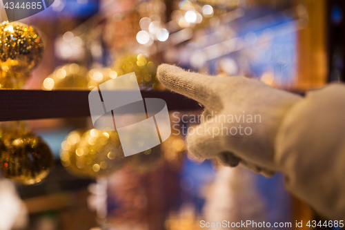 Image of hand pointing at christmas toys behind shop window