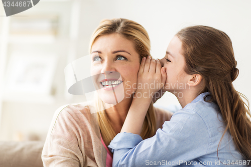 Image of happy girl whispering secret to her mother at home