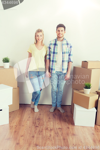 Image of smiling couple with big boxes moving to new home