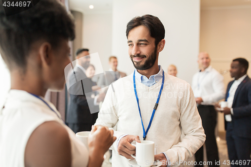 Image of business people with conference badges and coffee