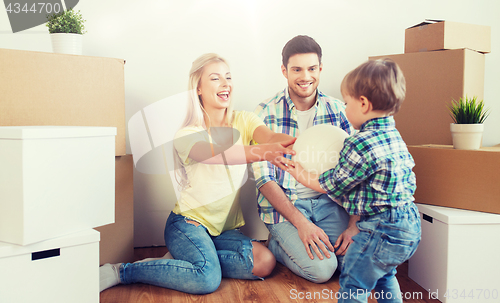 Image of happy family moving to new home and playing ball