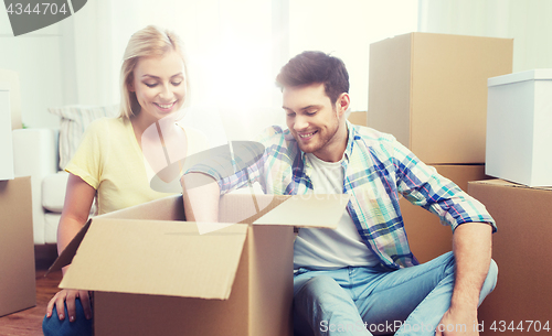 Image of smiling couple with big boxes moving to new home