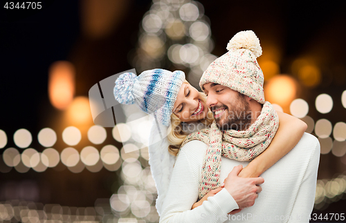 Image of happy couple hugging over christmas lights