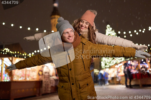 Image of happy couple having fun at christmas market