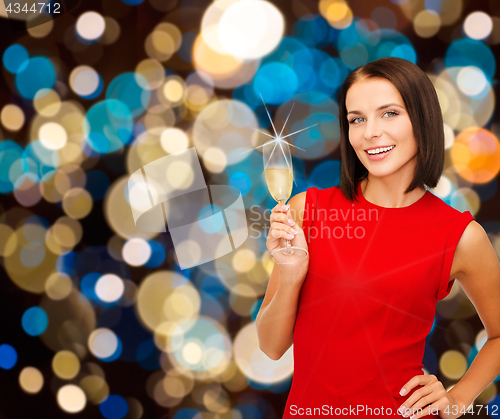 Image of smiling woman holding glass of sparkling wine