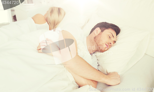 Image of couple sleeping in bed at home