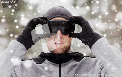 Image of sports man with ski goggles in winter outdoors