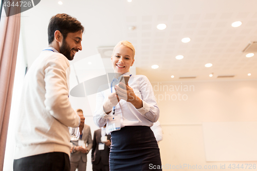 Image of couple with smartphone at business conference