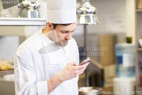 Image of chef cook with smartphone at restaurant kitchen