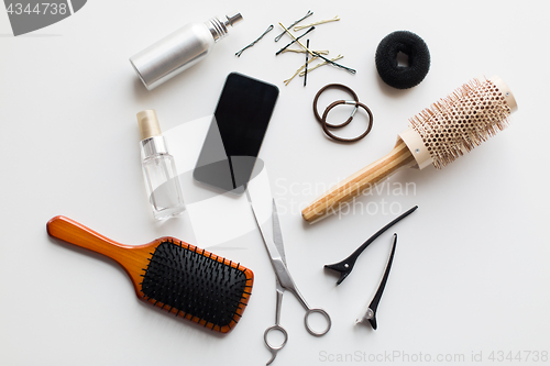 Image of smartphone, scissors, brushes and other hair tools