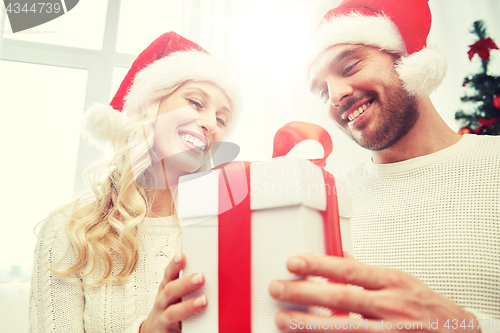 Image of happy couple at home with christmas gift box