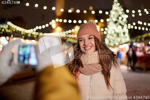 Image of happy woman posing for smartphone at christmas