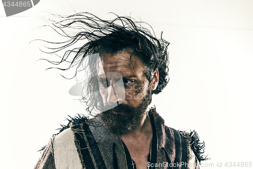 Image of Portrait of a brutal bald-headed viking in a battle posing against a white background.