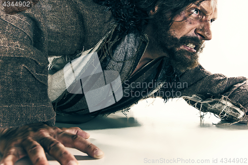 Image of Portrait of a brutal bald-headed viking in a battle mail posing against a white background.