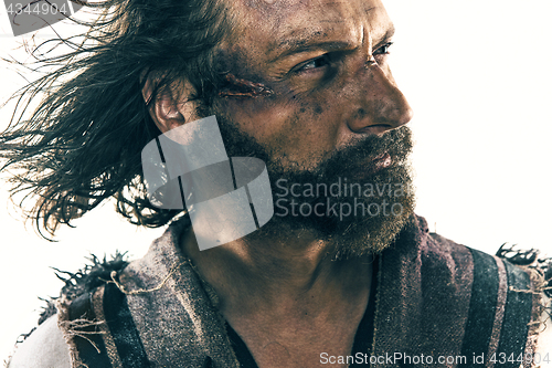 Image of Portrait of a brutal bald-headed viking in a battle posing against a white background.