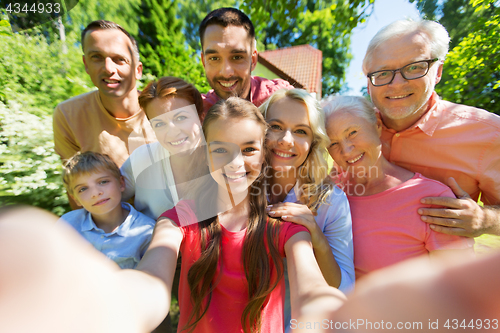 Image of happy family taking selfie in summer garden