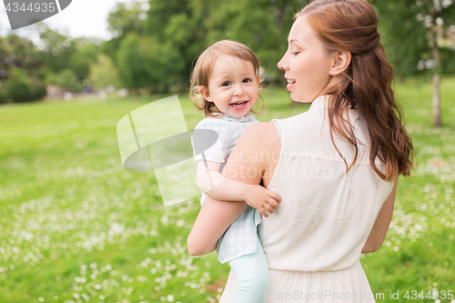 Image of happy mother holding baby girl at summer park