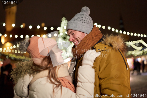 Image of happy couple holding hands at christmas tree