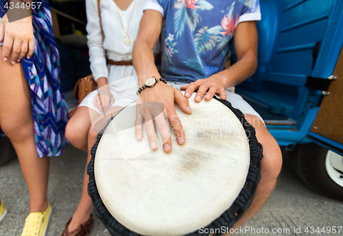 Image of close up of hippie friends playing tom-tom drum