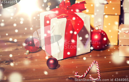 Image of gifts, candies and christmas balls on wooden board