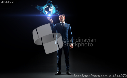 Image of businessman with earth hologram over black