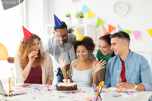 Image of team greeting colleague at office birthday party