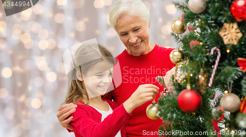Image of grandmother and granddaughter at christmas tree