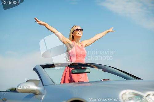 Image of happy young woman in convertible car