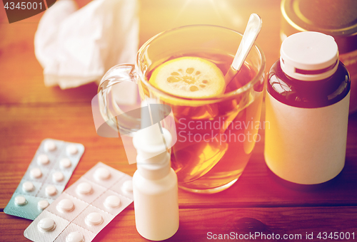 Image of cup of tea, drugs, honey and paper tissue on wood