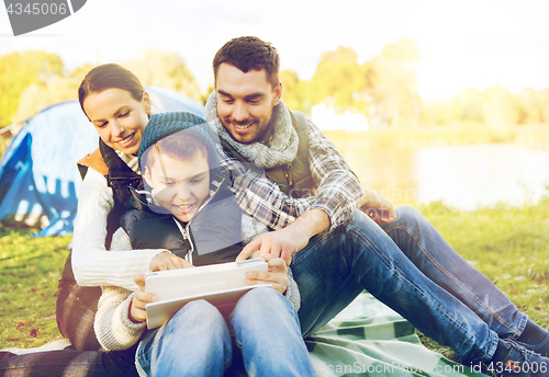 Image of happy family with tablet pc and tent at camp site