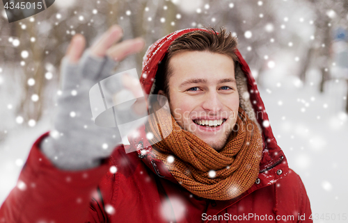 Image of happy man in winter jacket showing ok hand sign