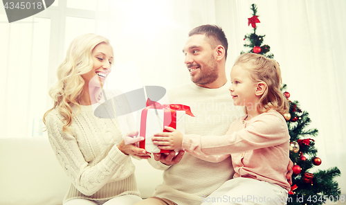 Image of happy family at home with christmas gift box