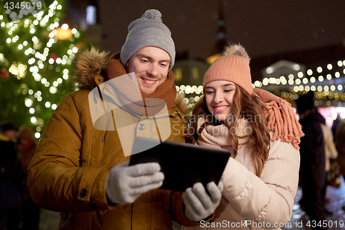 Image of happy couple with tablet pc at christmas market