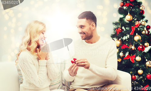 Image of man giving woman engagement ring for christmas