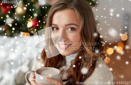 Image of happy woman drinking cocoa at home for christmas
